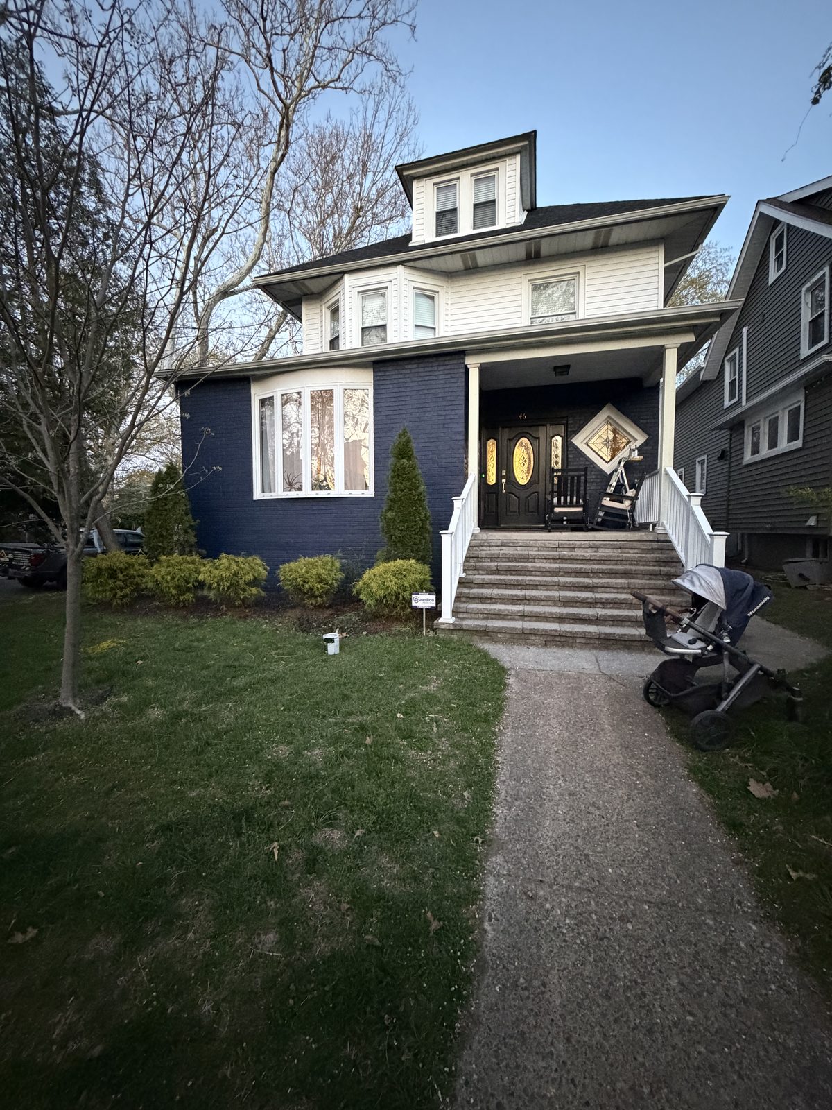 Navy blue painted brick home exterior with white trim and covered front porch