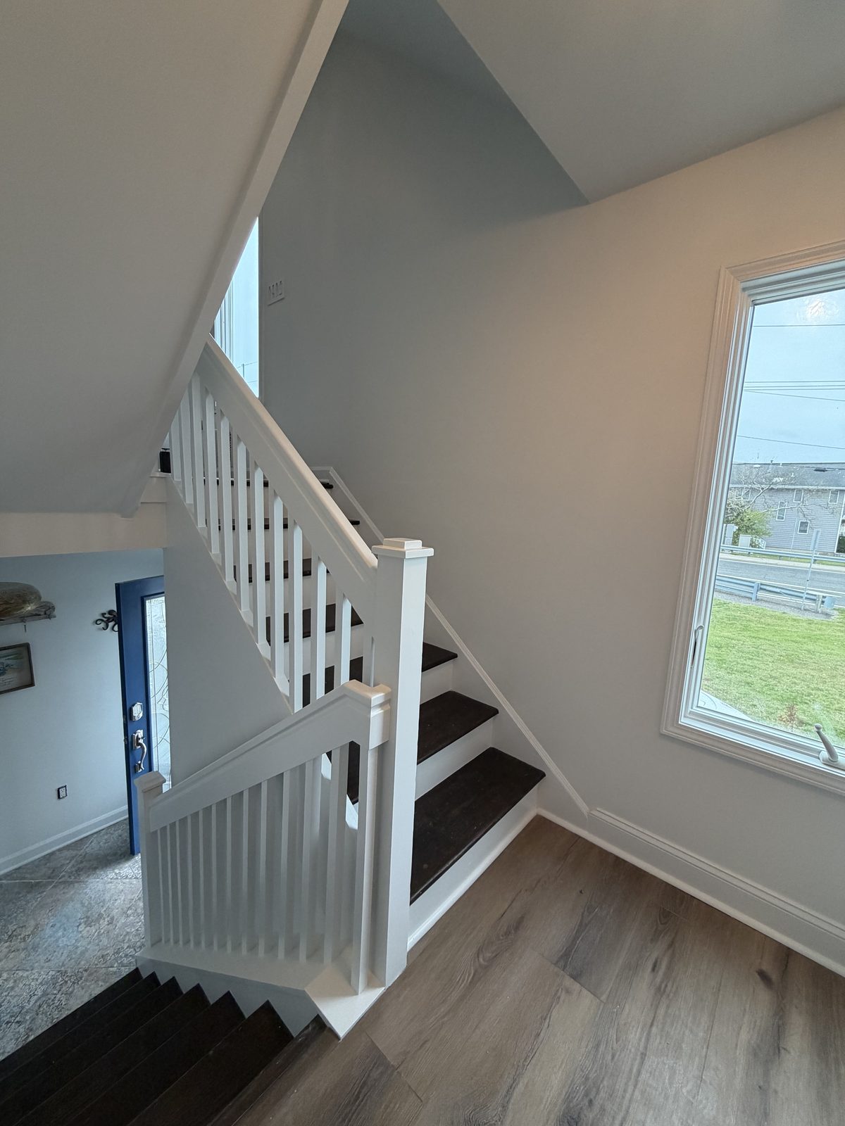 Freshly painted white staircase railing and trim with dark stair treads